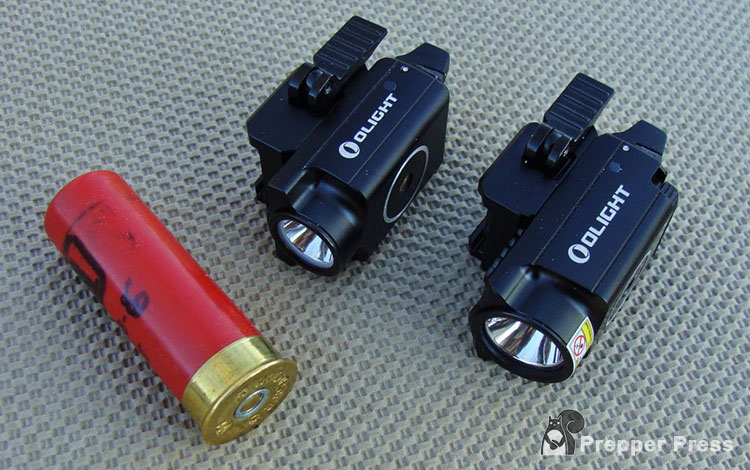 two Olight weapon lights next to shotgun shell
