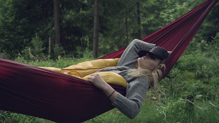 woman relaxing in hammock while camping