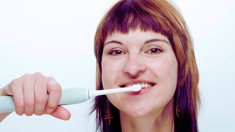 woman dry brushing her teeth