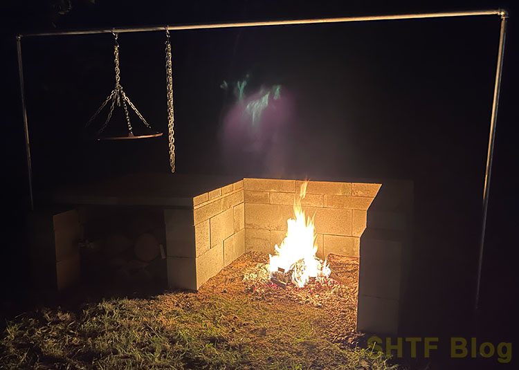 fire pit with cooking setup at night