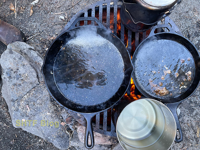 cast iron skillet with water heating up over a fire